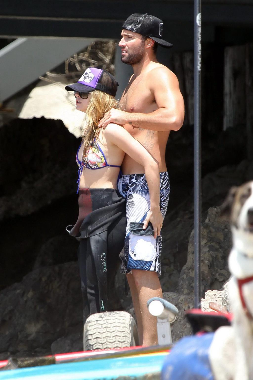 13P Avril Lavigne wearing a bikini top and a wetsuit on the beach in Malibu