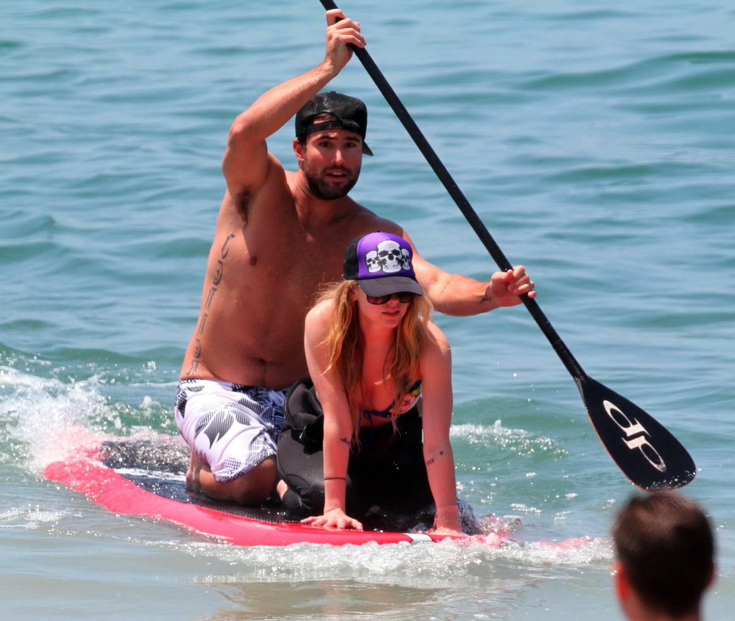 13P Avril Lavigne wearing a bikini top and a wetsuit on the beach in Malibu