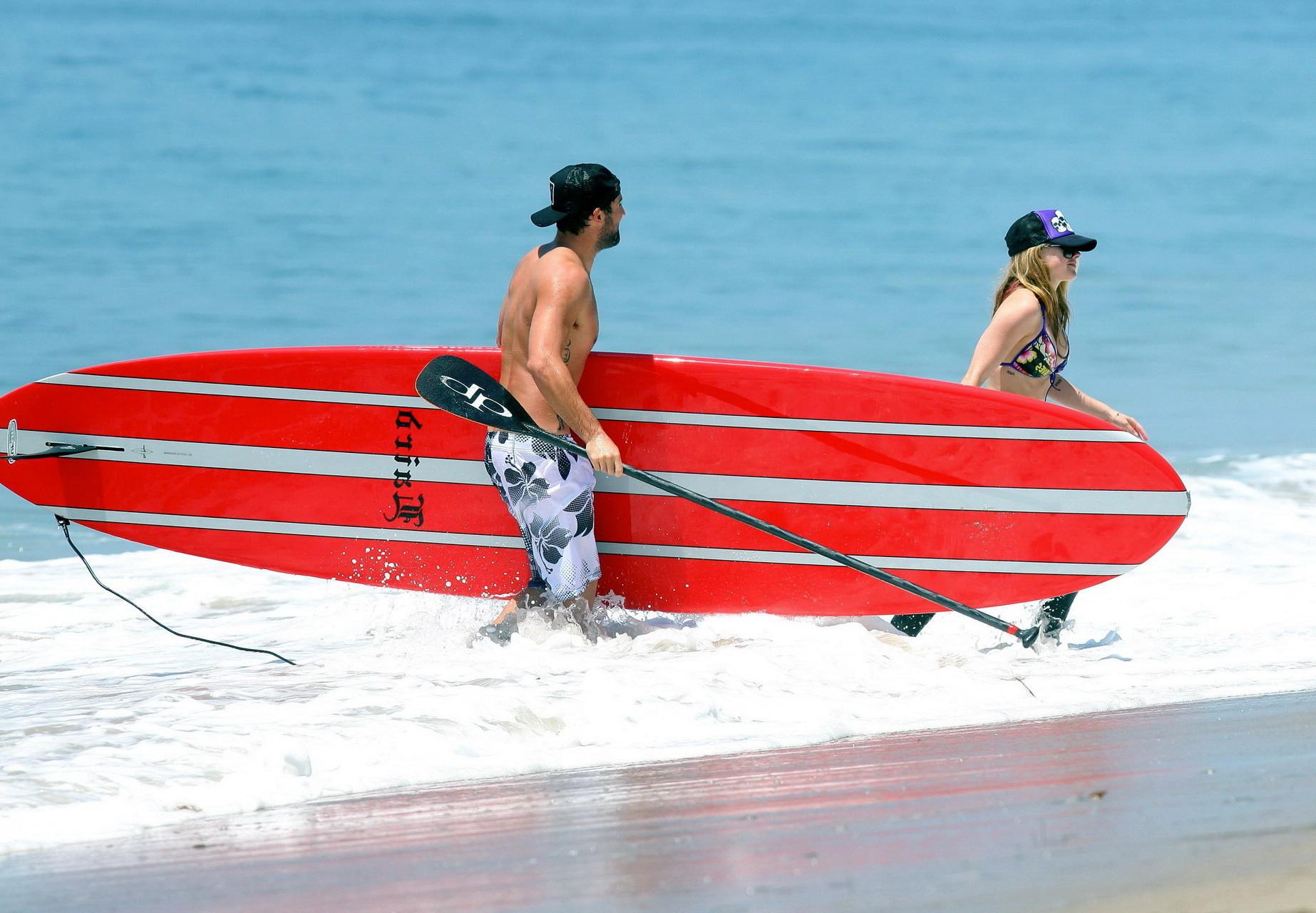 13P Avril Lavigne wearing a bikini top and a wetsuit on the beach in Malibu