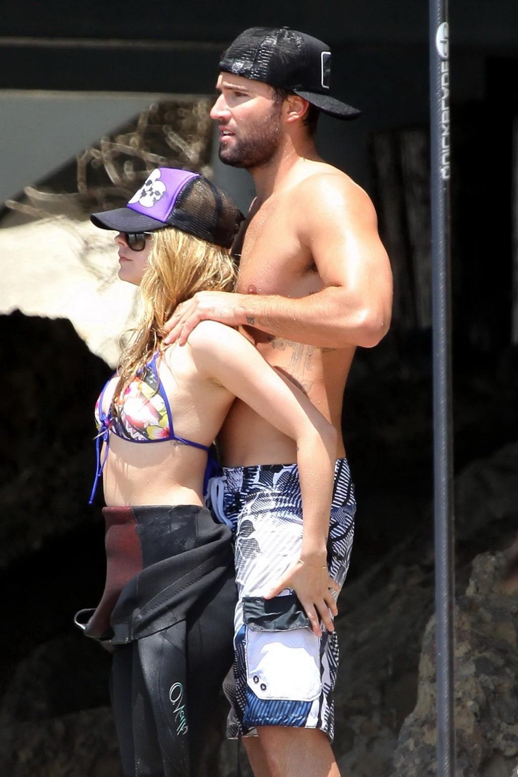 13P Avril Lavigne wearing a bikini top and a wetsuit on the beach in Malibu