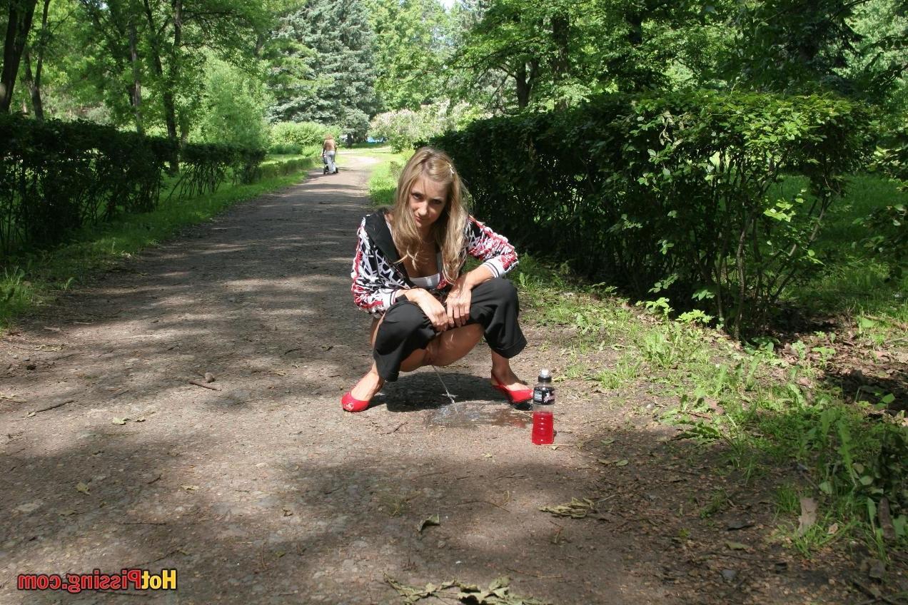 15P Young blondie with long hair has a piss in the middle of a park road
