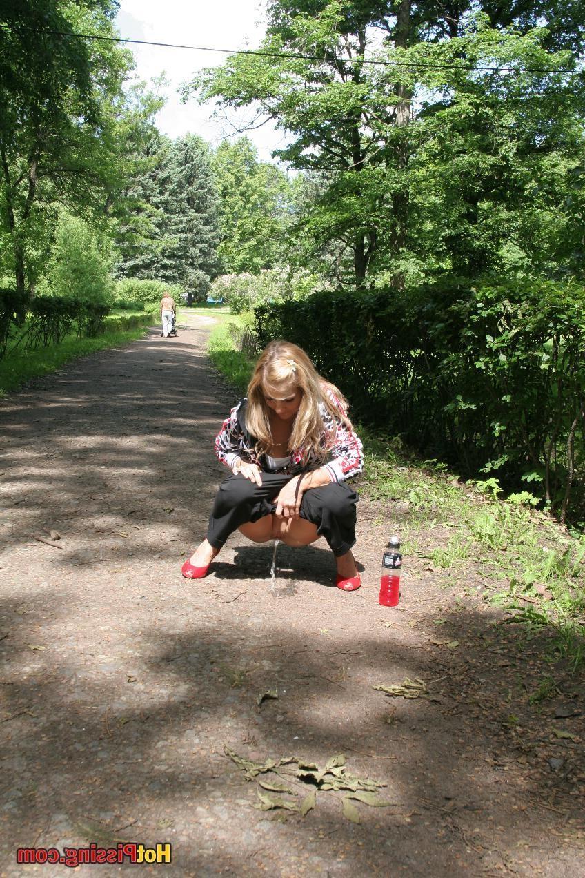 15P Young blondie with long hair has a piss in the middle of a park road