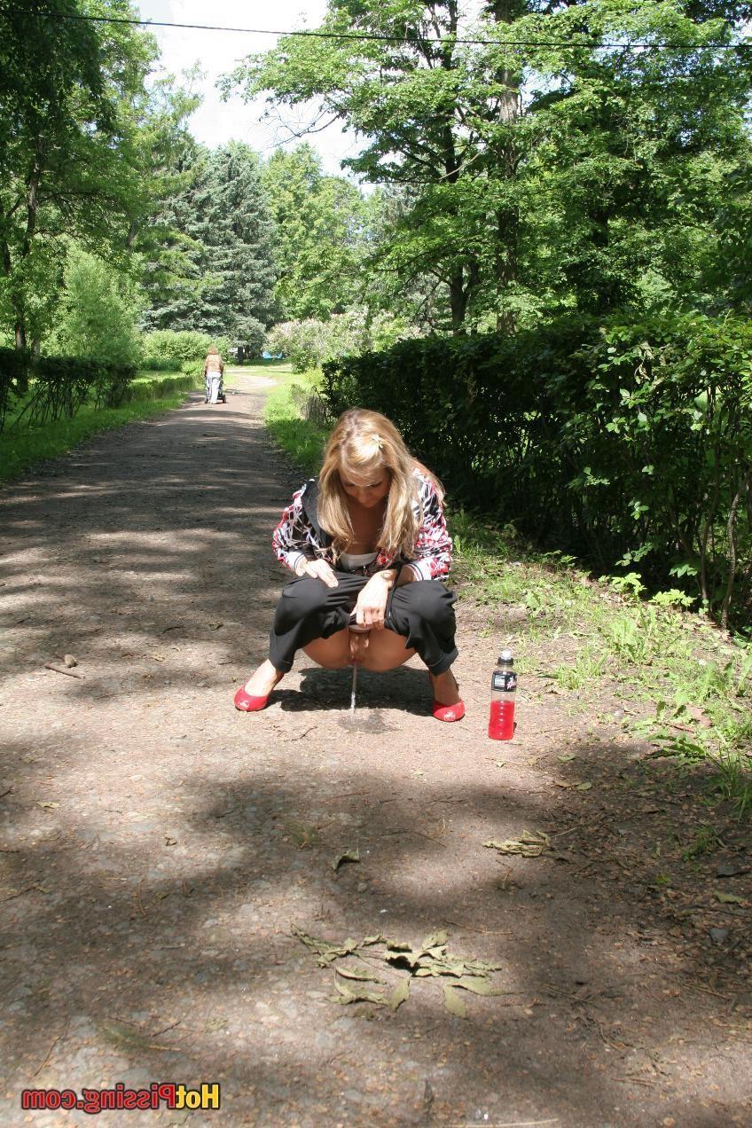 15P Young blondie with long hair has a piss in the middle of a park road