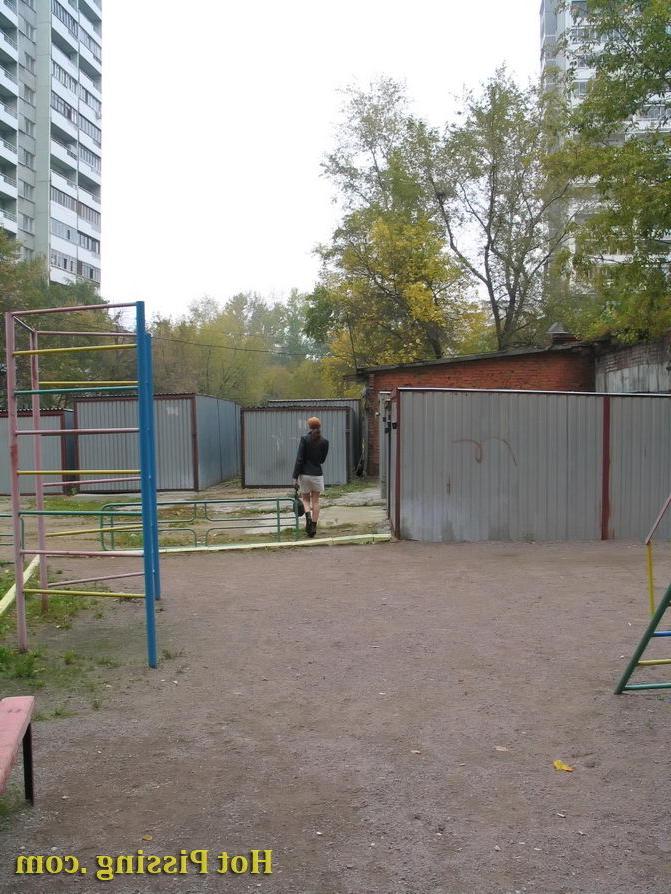 15P Hidden camera photos of a redhead girl having a pee behind a building