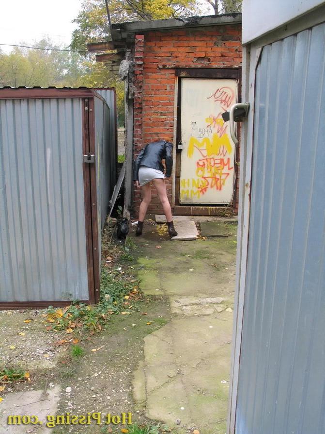 15P Hidden camera photos of a redhead girl having a pee behind a building