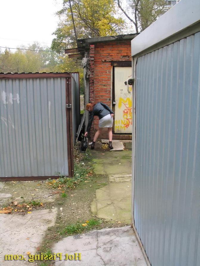 15P Hidden camera photos of a redhead girl having a pee behind a building