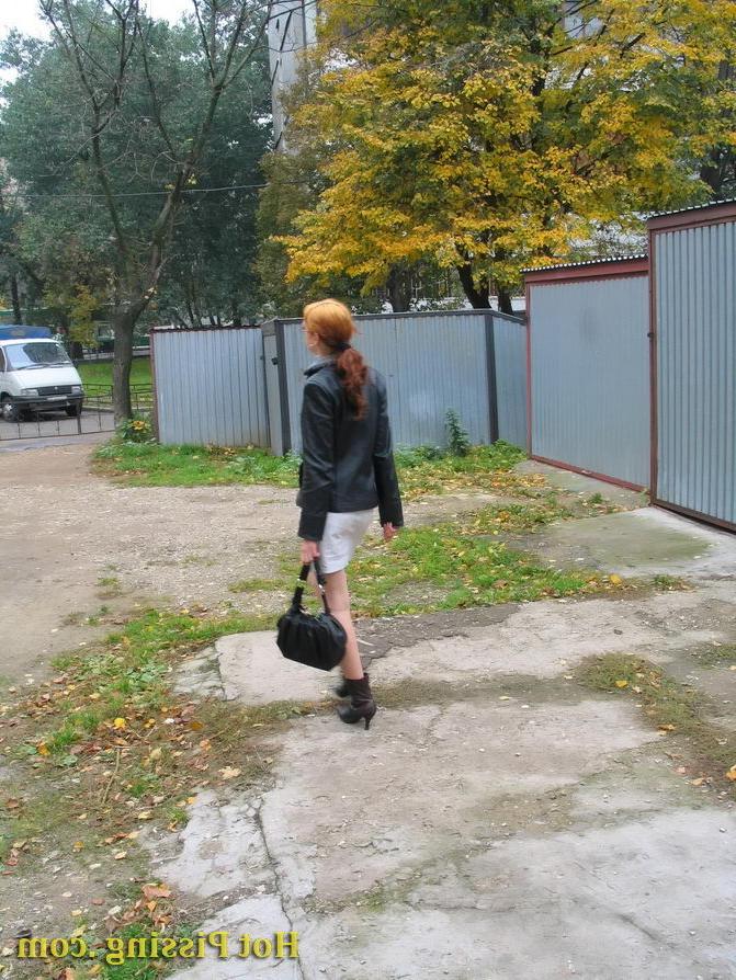 15P Hidden camera photos of a redhead girl having a pee behind a building