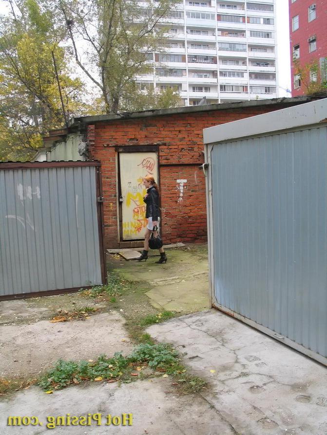15P Hidden camera photos of a redhead girl having a pee behind a building