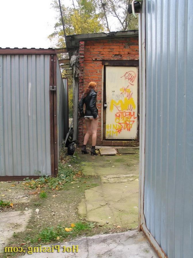15P Hidden camera photos of a redhead girl having a pee behind a building