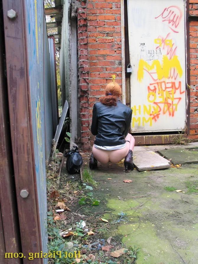 15P Hidden camera photos of a redhead girl having a pee behind a building