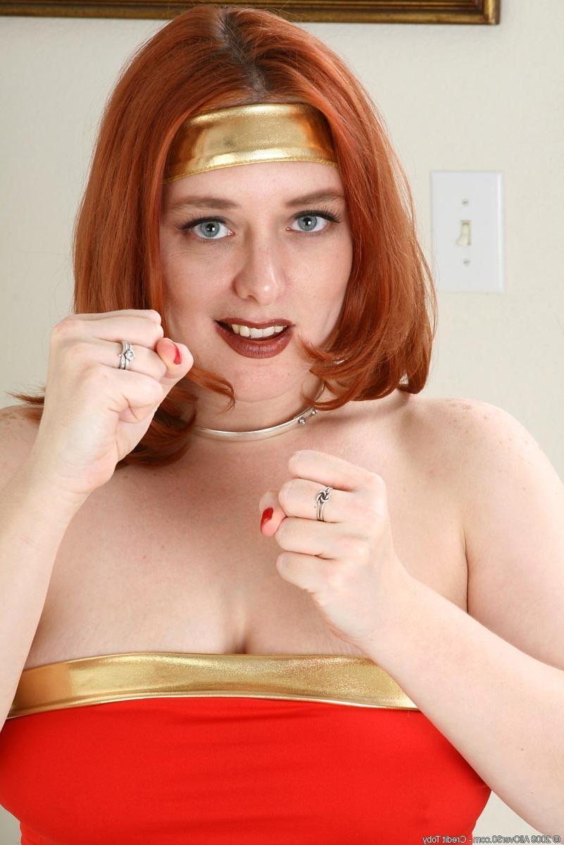 15P Busty redhead milf stripping off her sexy wonder woman outfit