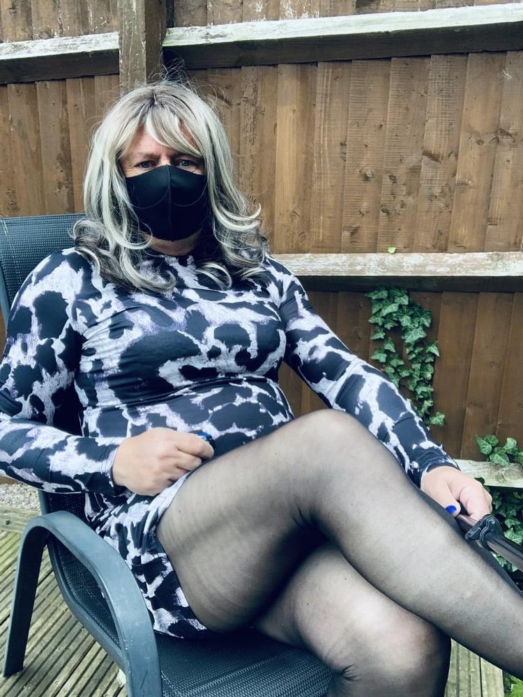 25P Kelly trägt ein Kleid mit Leopardenmuster, schwarze Strumpfhosen und High Heels