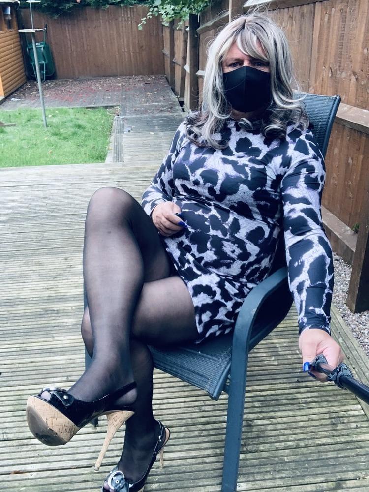 25P Kelly trägt ein Kleid mit Leopardenmuster, schwarze Strumpfhosen und High Heels
