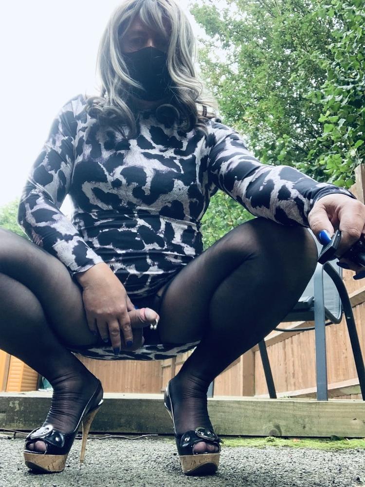 25P Kelly trägt ein Kleid mit Leopardenmuster, schwarze Strumpfhosen und High Heels