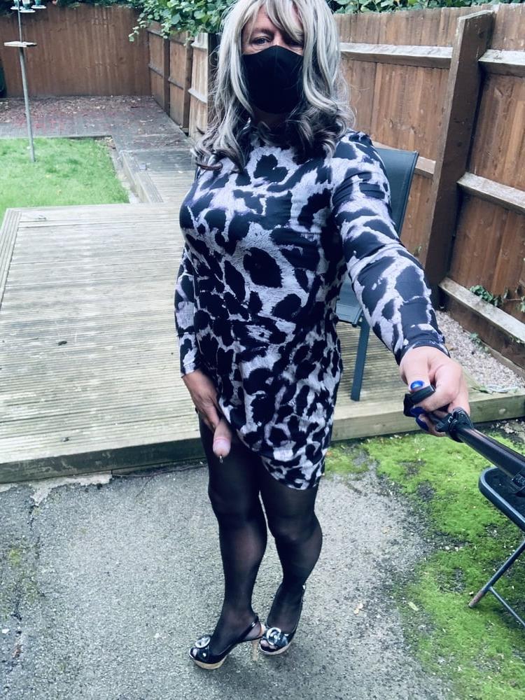 25P Kelly trägt ein Kleid mit Leopardenmuster, schwarze Strumpfhosen und High Heels