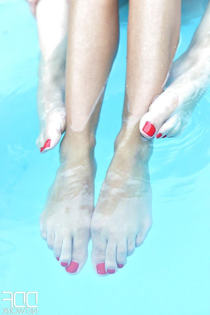 16P Leggy lesbians Danielle Maye and Loulou Petite suck toes in swimming pool