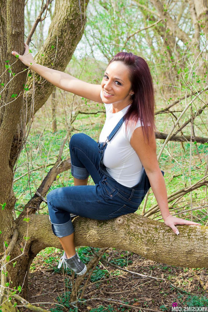 15P Busty hottie Nikki Sims teases in the woods in her overalls