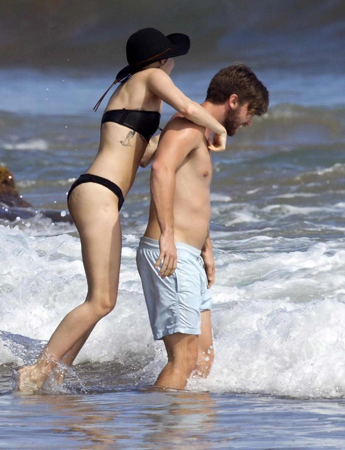 16P Miley Cyrus showing off her bikini body and getting her ass groped on a Hawaiian