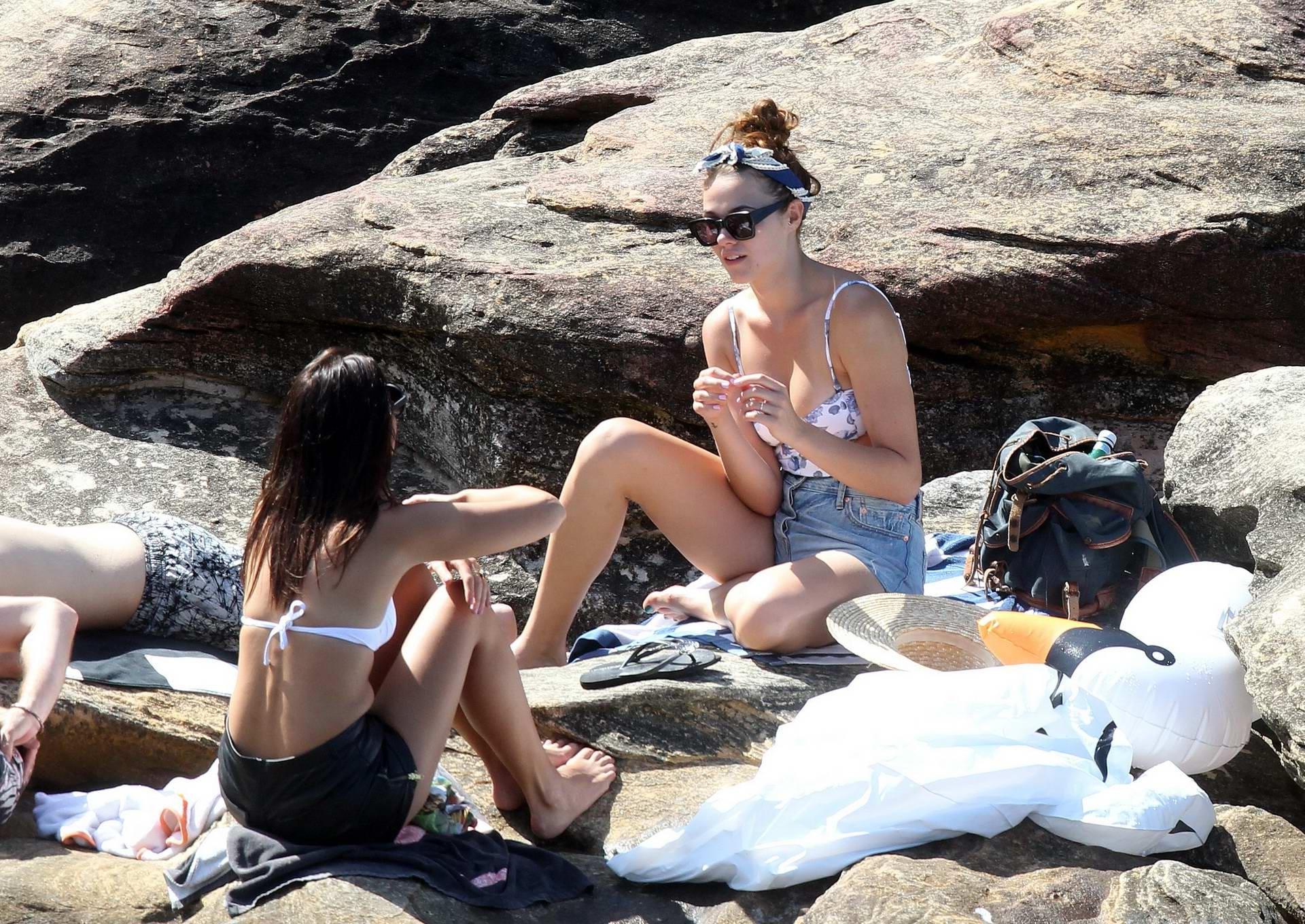 16P Demi Harman busty wearing a swimsuit on a rocky beach in Sydney
