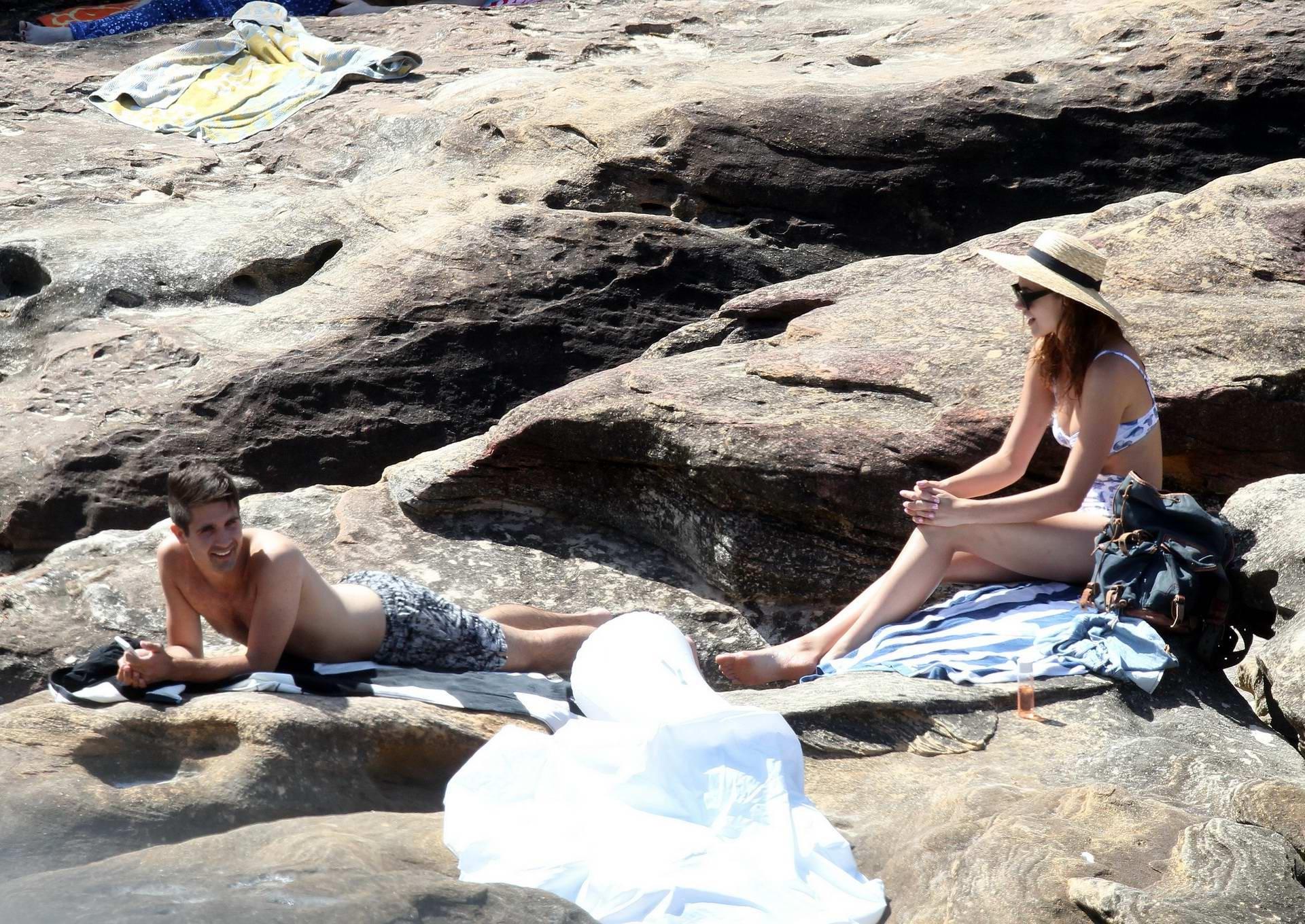 16P Demi Harman busty wearing a swimsuit on a rocky beach in Sydney