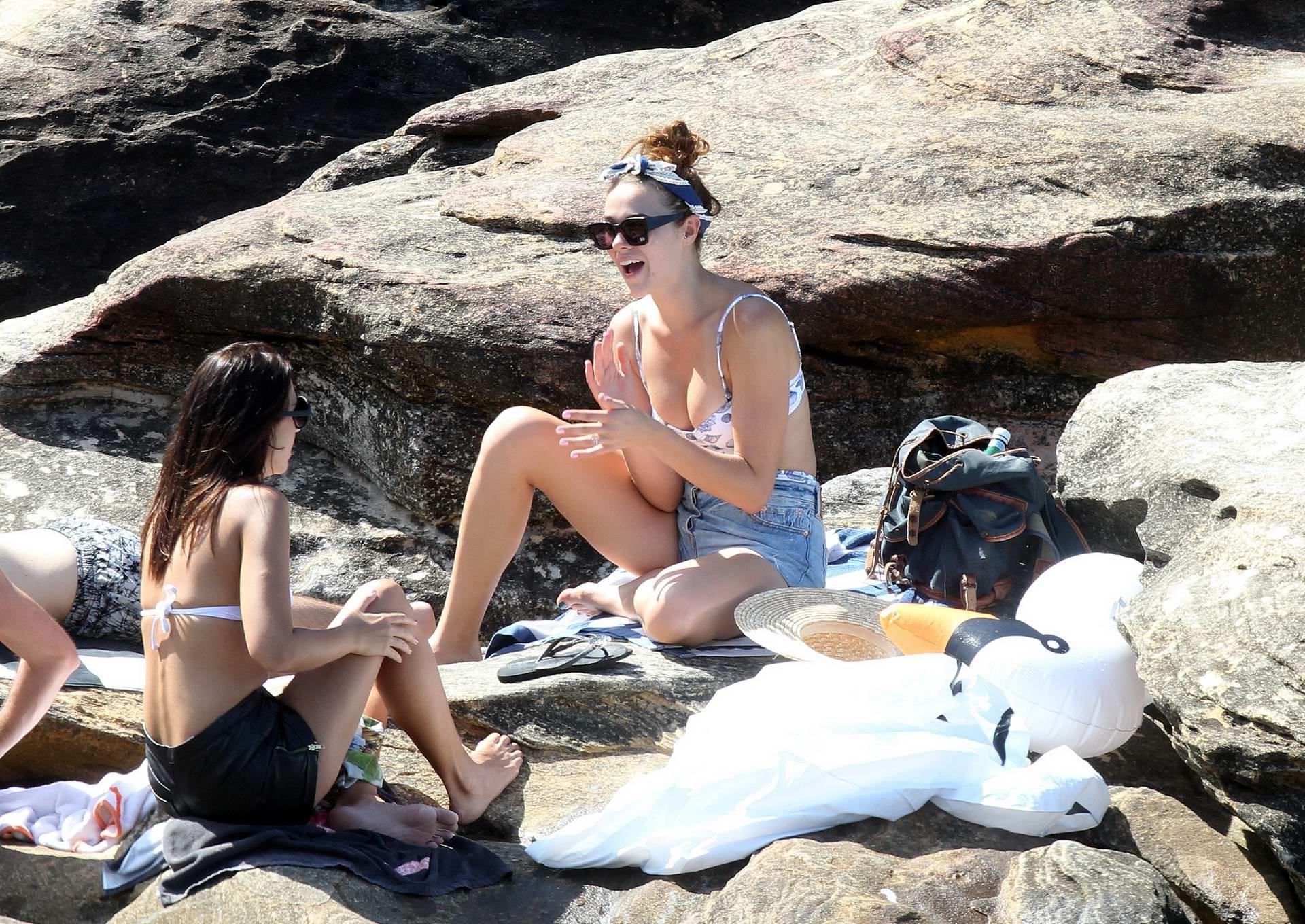 16P Demi Harman busty wearing a swimsuit on a rocky beach in Sydney