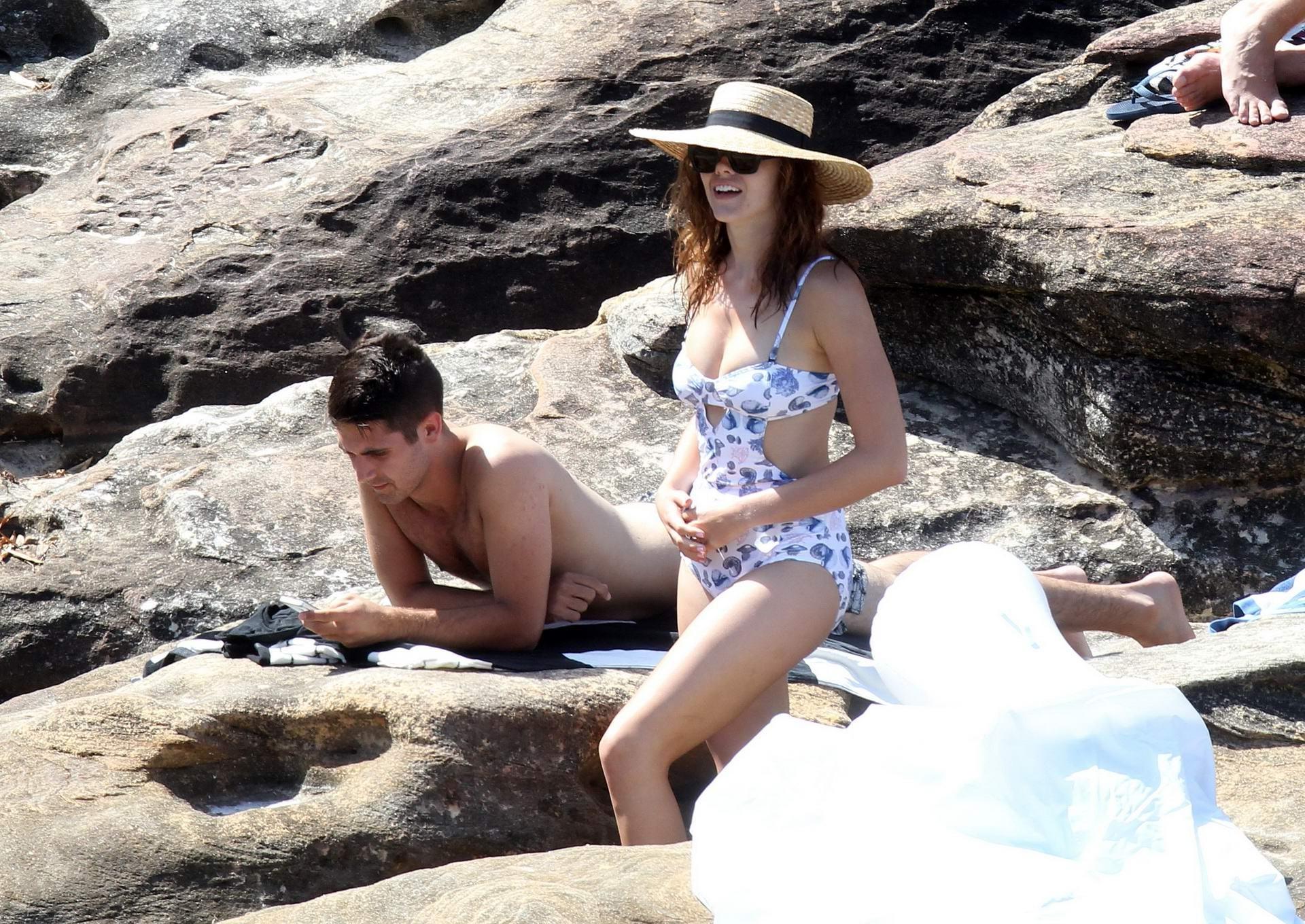 16P Demi Harman busty wearing a swimsuit on a rocky beach in Sydney