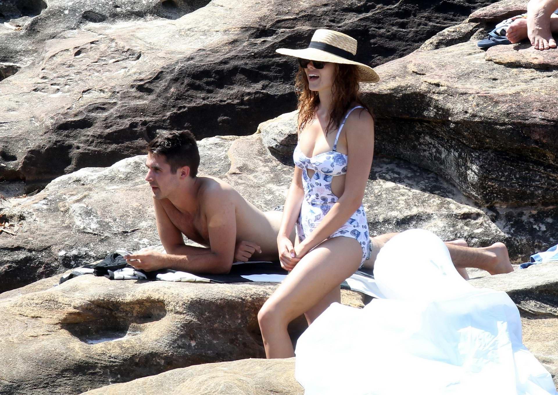 16P Demi Harman busty wearing a swimsuit on a rocky beach in Sydney