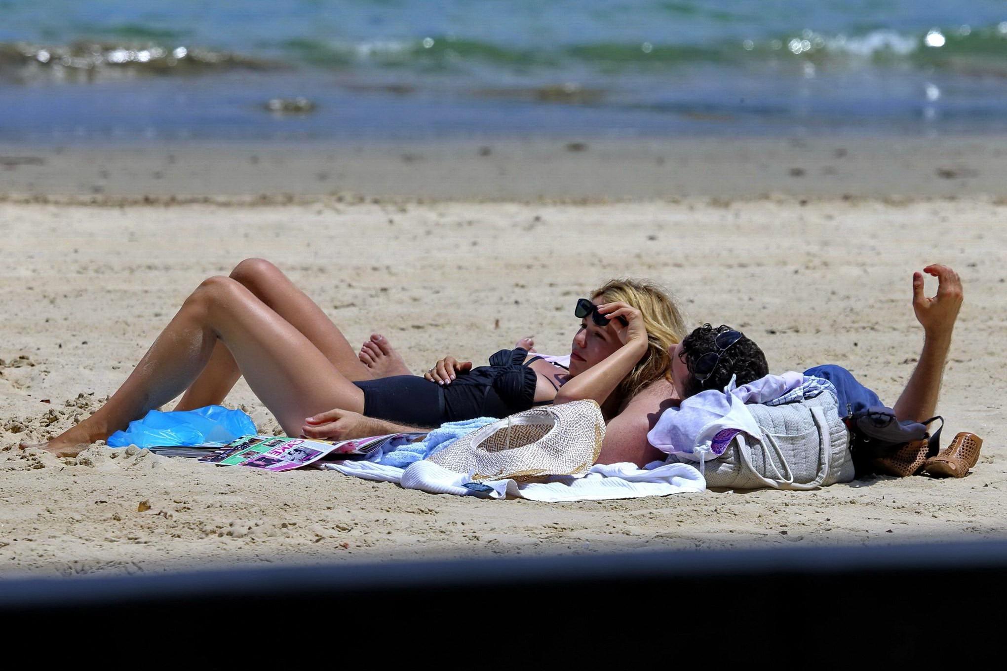 16P Tammin Sursok wearing a black swimsuit on a beach in Sydney