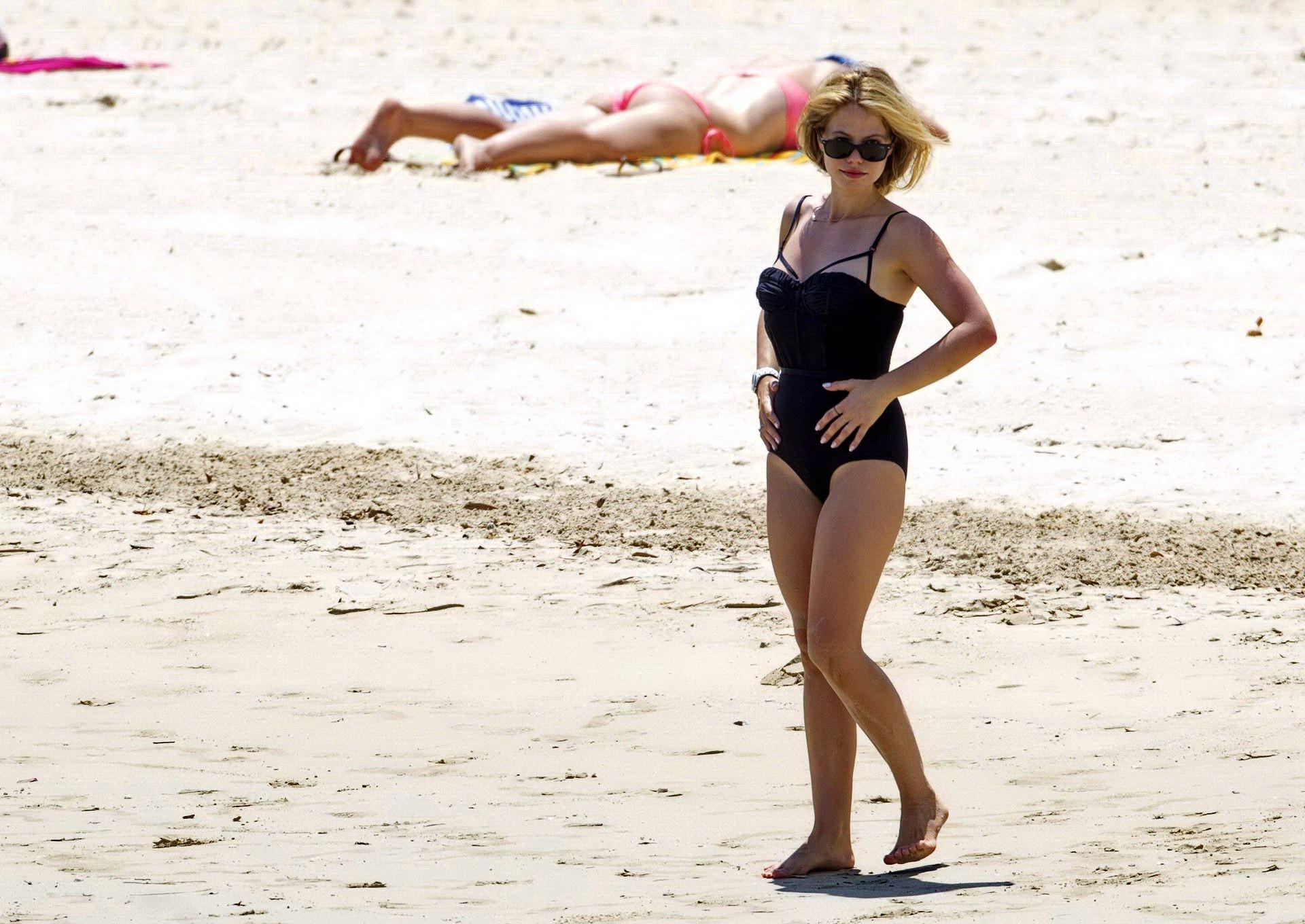16P Tammin Sursok wearing a black swimsuit on a beach in Sydney