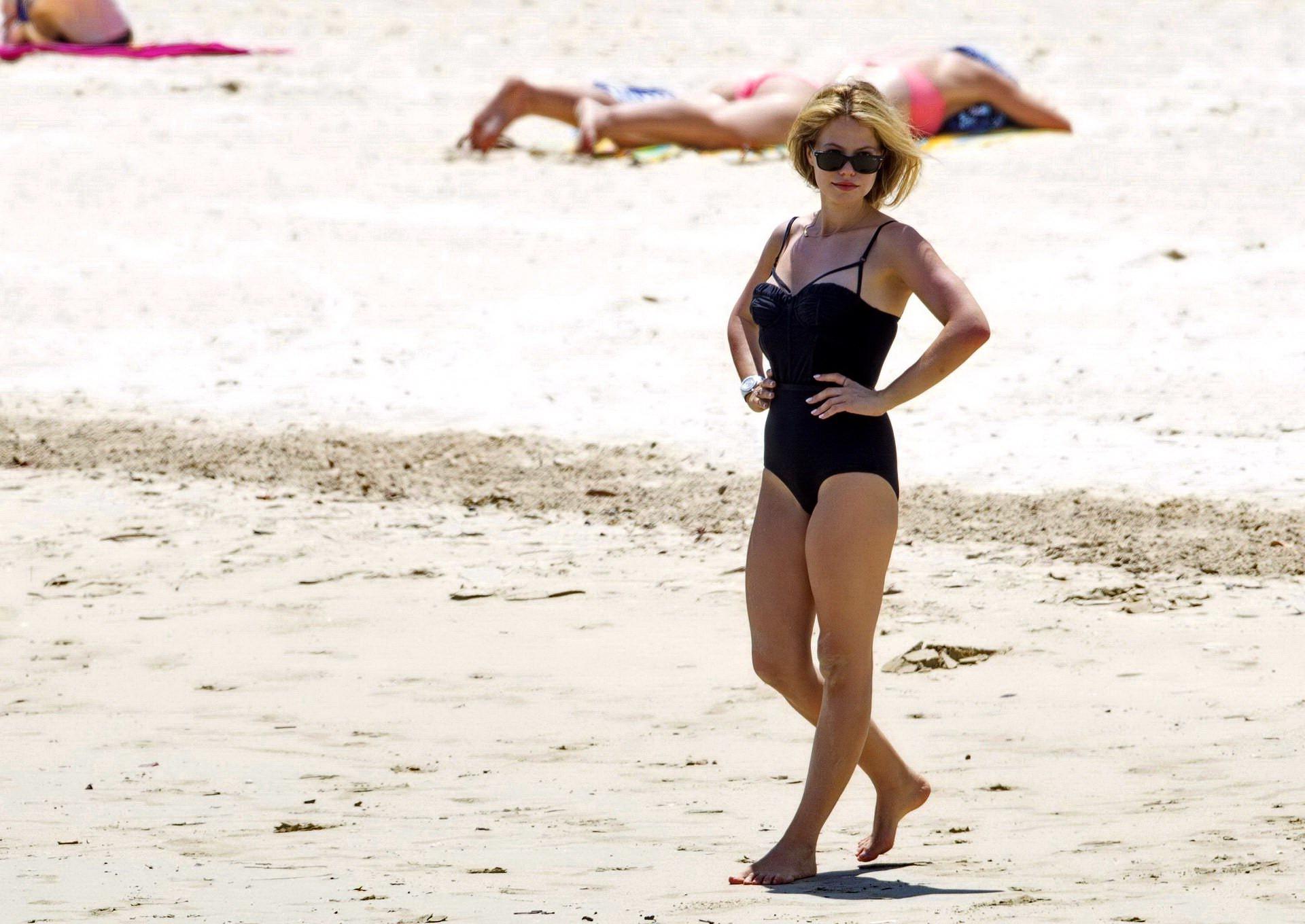 16P Tammin Sursok wearing a black swimsuit on a beach in Sydney