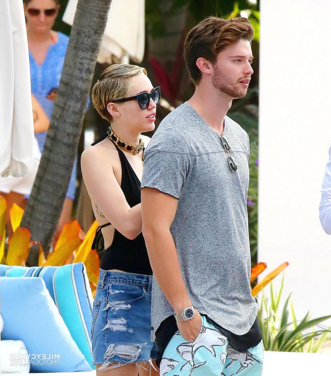 16P Miley Cyrus wearing swimsuit and hotpants at a pool in Miami