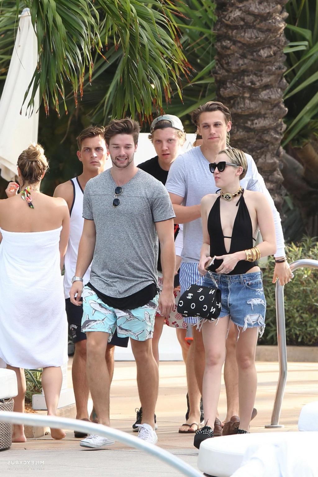 16P Miley Cyrus wearing swimsuit and hotpants at a pool in Miami
