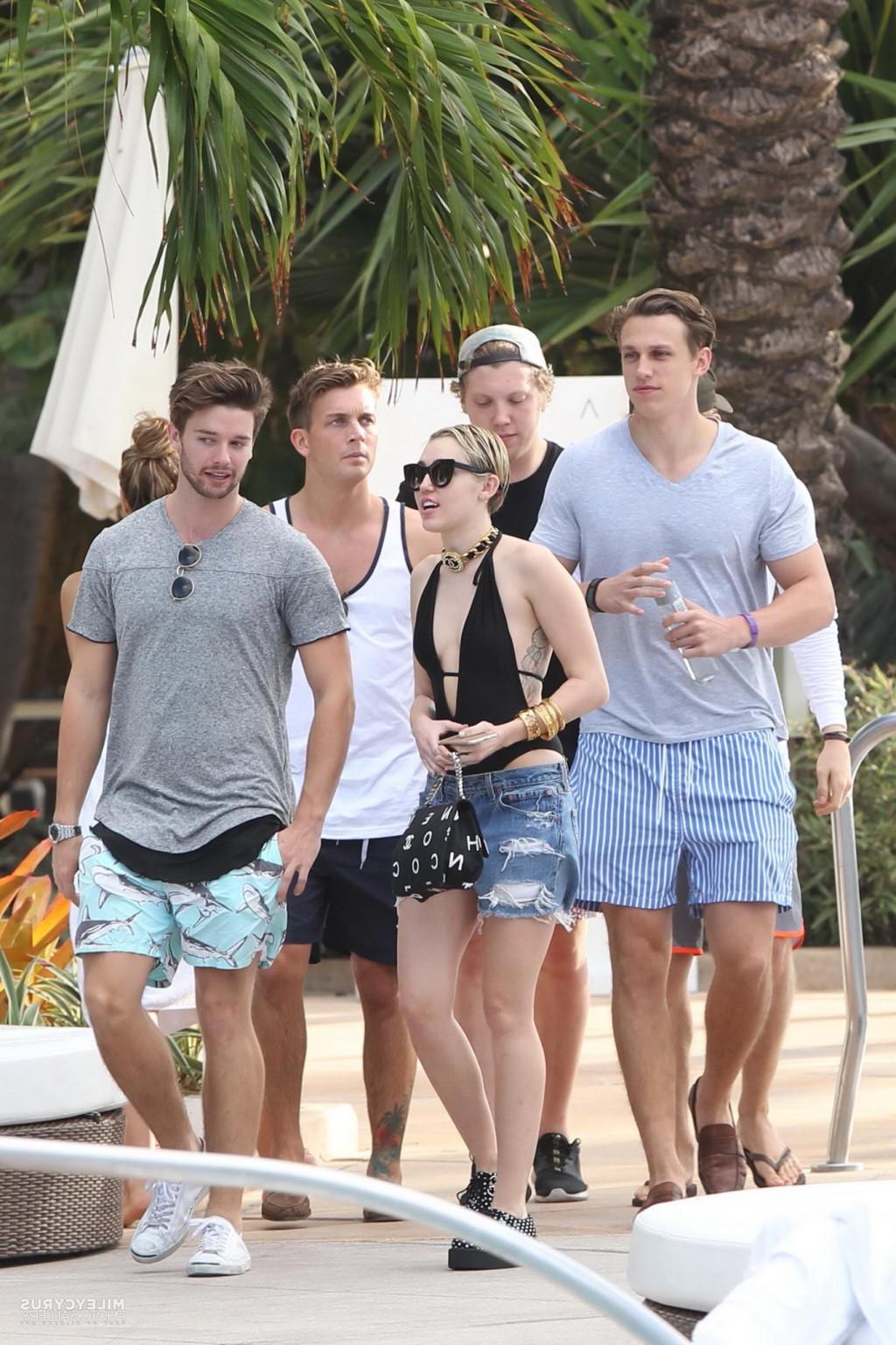 16P Miley Cyrus wearing swimsuit and hotpants at a pool in Miami