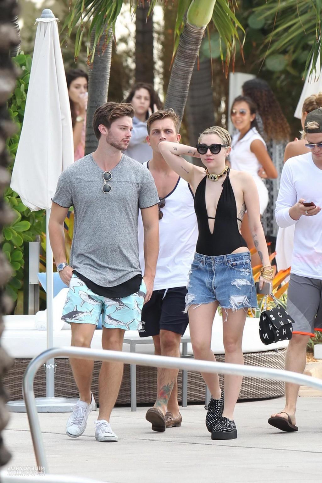 16P Miley Cyrus wearing swimsuit and hotpants at a pool in Miami