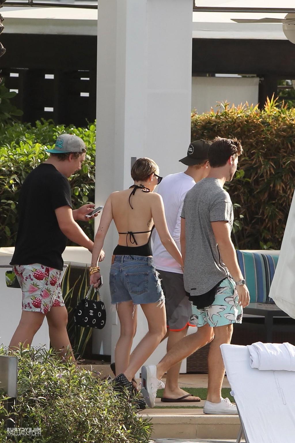 16P Miley Cyrus wearing swimsuit and hotpants at a pool in Miami