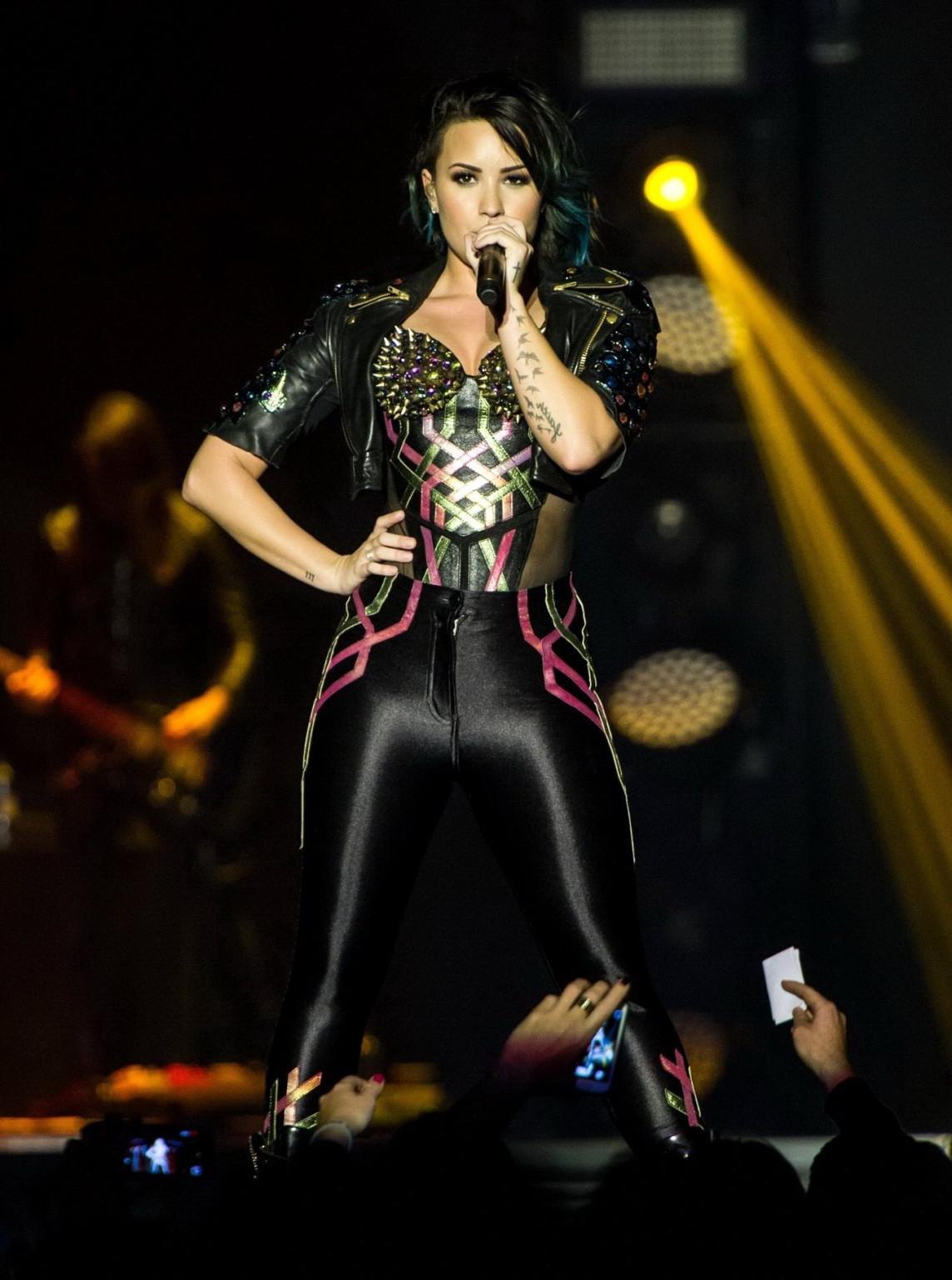 16P Demi Lovato wearing tights and spiky corset on stage in Birmingham