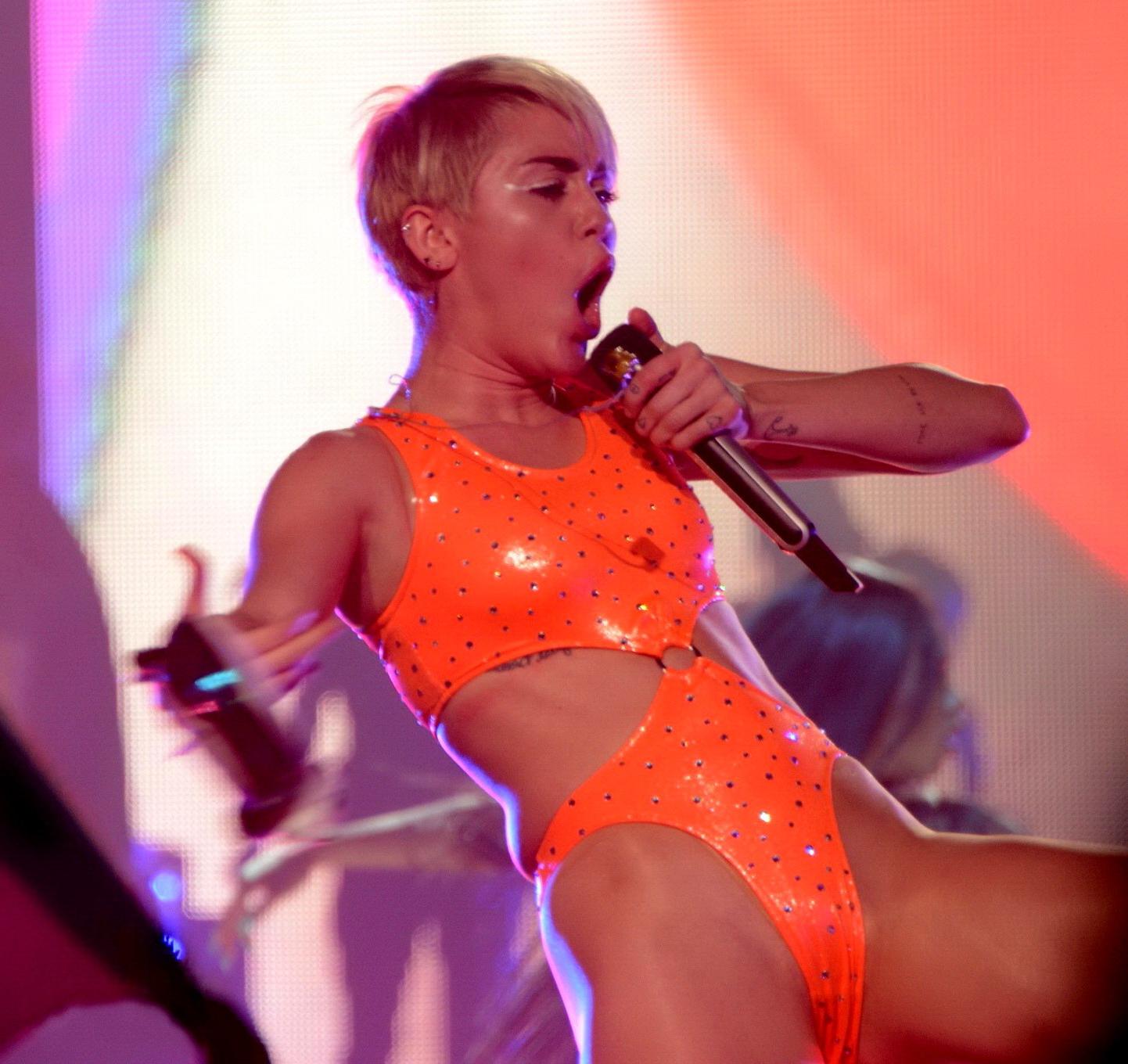 16P Miley Cyrus in an orange swimsuit performing at Bangerz Tour in San Juan Puerto 