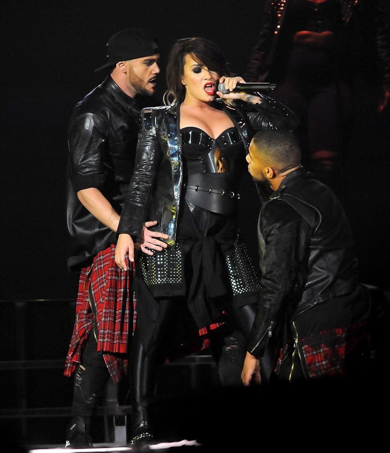 16P Demi Lovato in leather pants and metal corset performing on stage in Baltimore