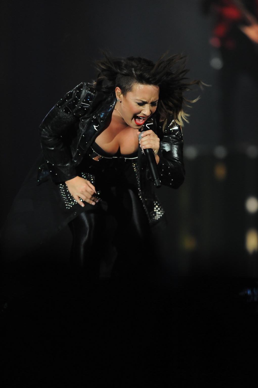 16P Demi Lovato in leather pants and metal corset performing on stage in Baltimore