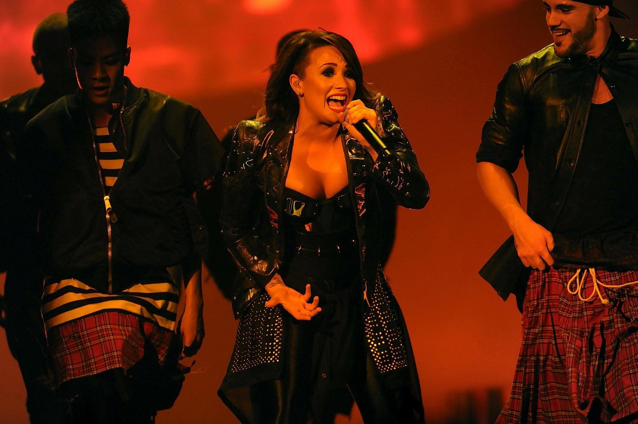 16P Demi Lovato in leather pants and metal corset performing on stage in Baltimore