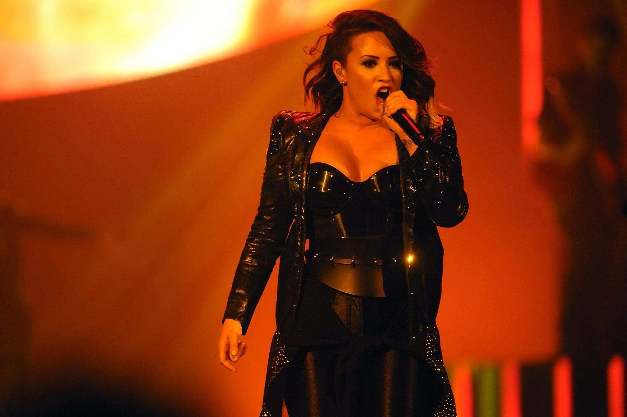 16P Demi Lovato in leather pants and metal corset performing on stage in Baltimore