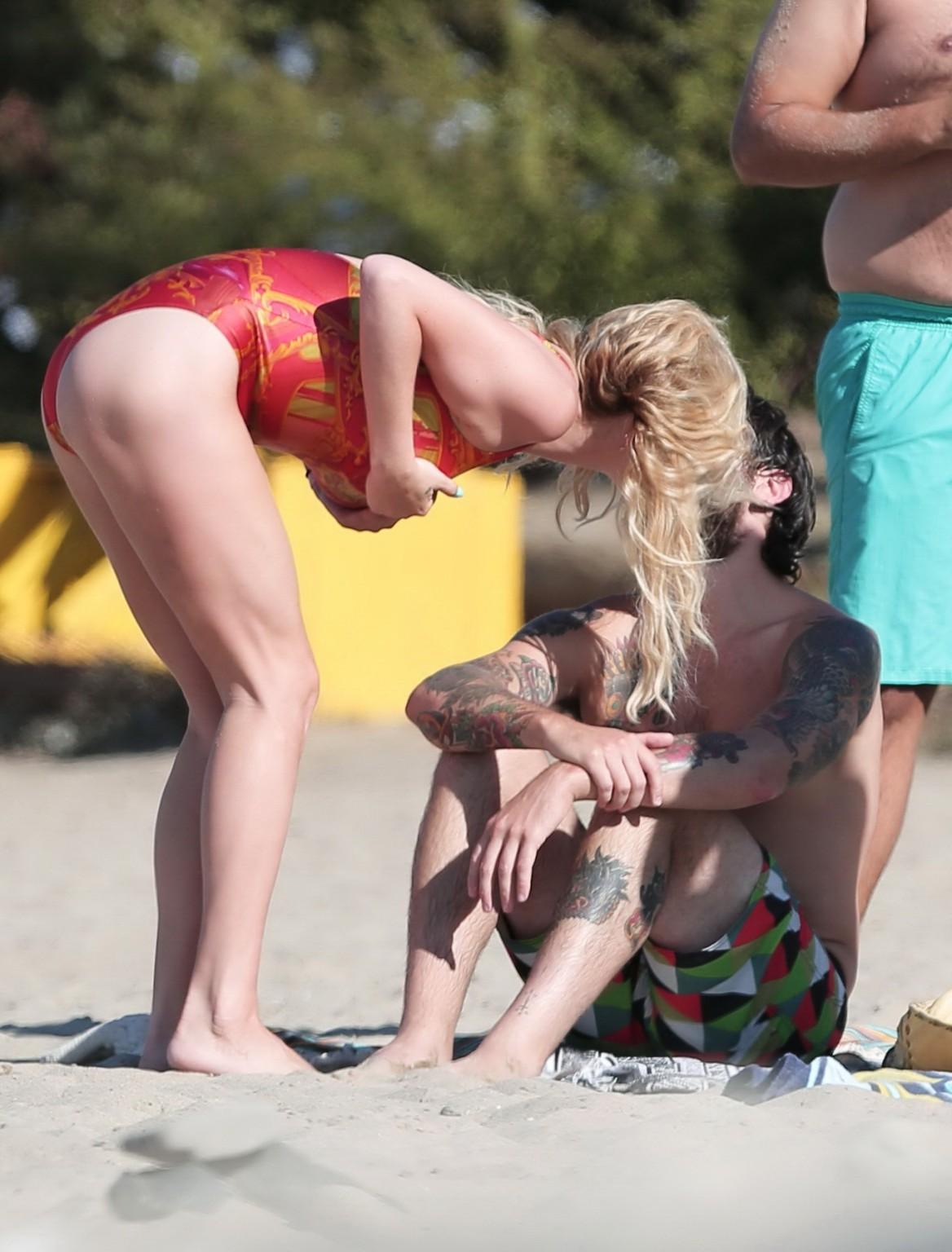 16P Kesha Sebert busty and booty in a red plunging swimsuit at the beach in Malibu