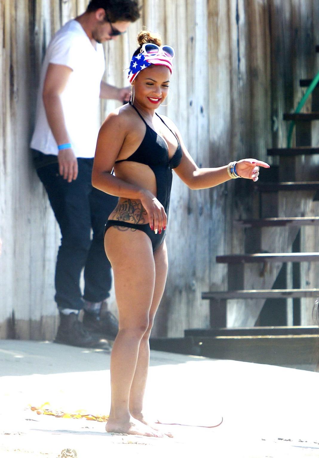16P Christina Milian wearing a sexy black swimsuit at Paris Hiltons 4th of July part