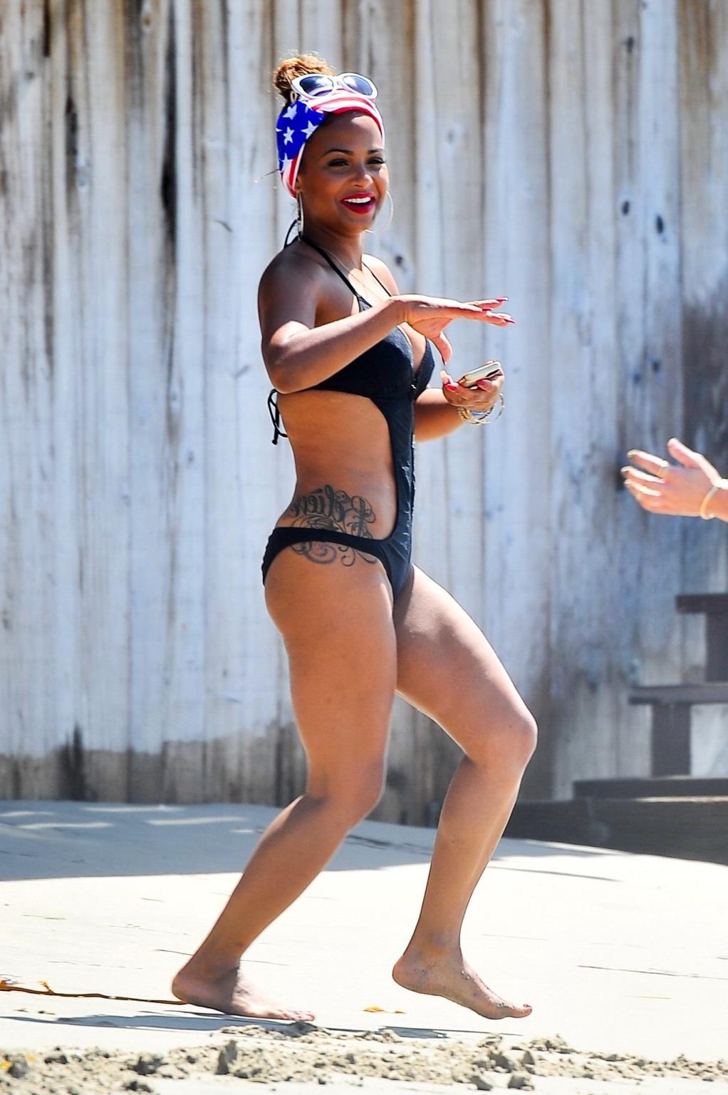 16P Christina Milian wearing a sexy black swimsuit at Paris Hiltons 4th of July part