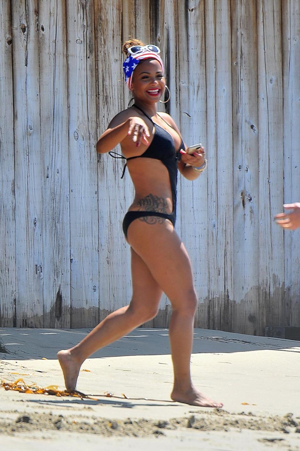 16P Christina Milian wearing a sexy black swimsuit at Paris Hiltons 4th of July part