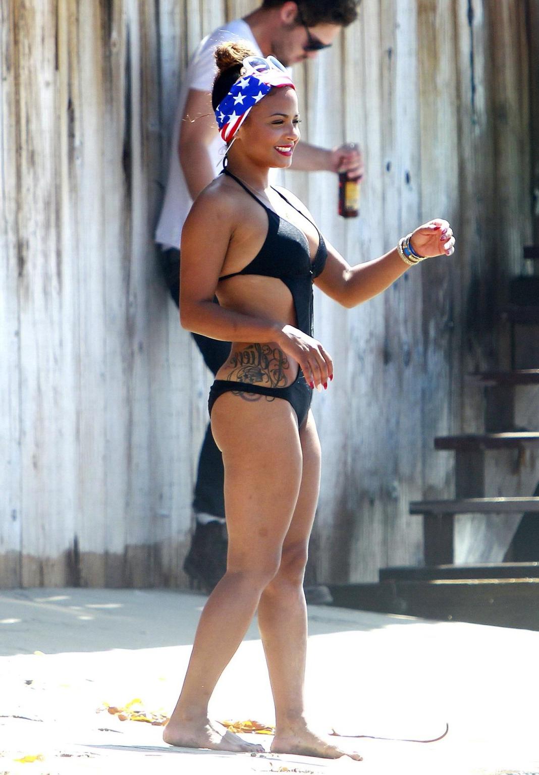 16P Christina Milian wearing a sexy black swimsuit at Paris Hiltons 4th of July part