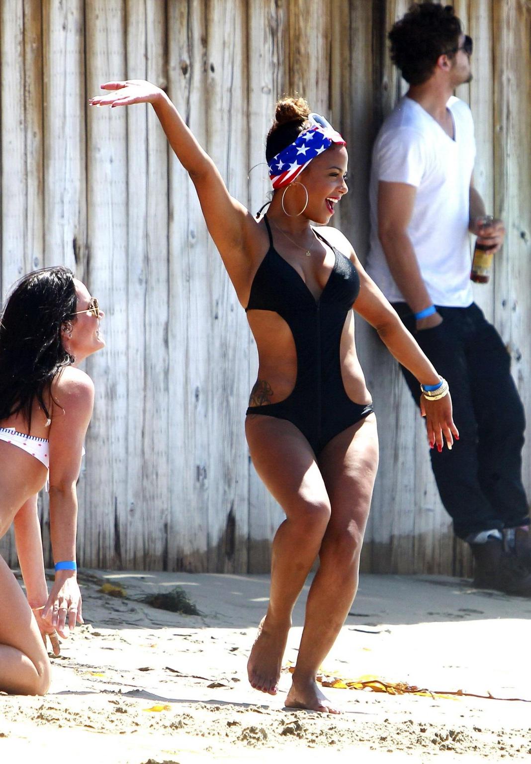 16P Christina Milian wearing a sexy black swimsuit at Paris Hiltons 4th of July part