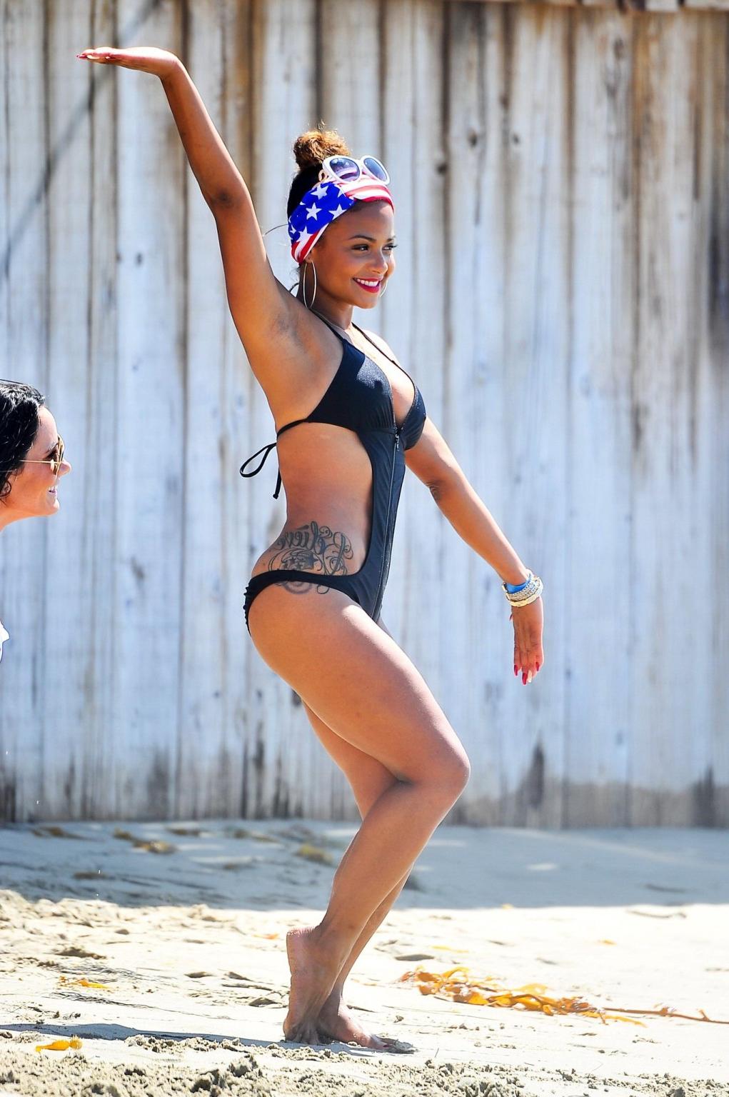 16P Christina Milian wearing a sexy black swimsuit at Paris Hiltons 4th of July part