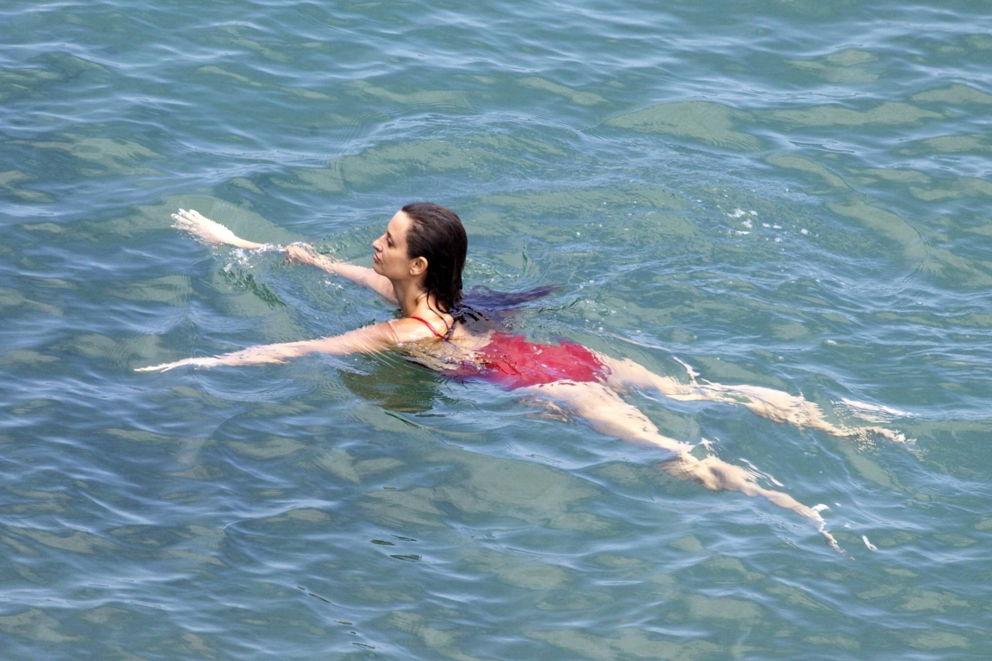 16P Penelope Cruz showing pokies on a beach wearing a sexy red swimsuit