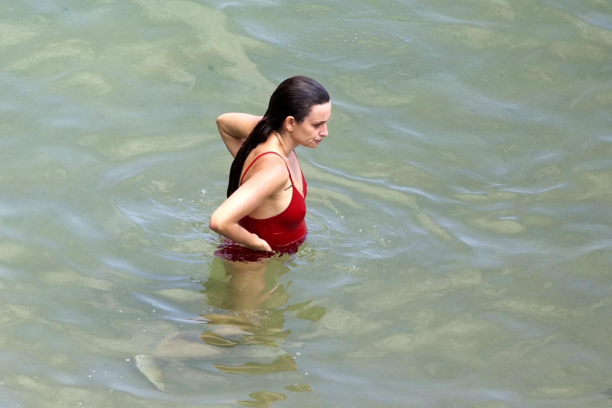 16P Penelope Cruz showing pokies on a beach wearing a sexy red swimsuit